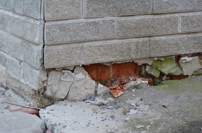 concrete bricks crumbling near base of house