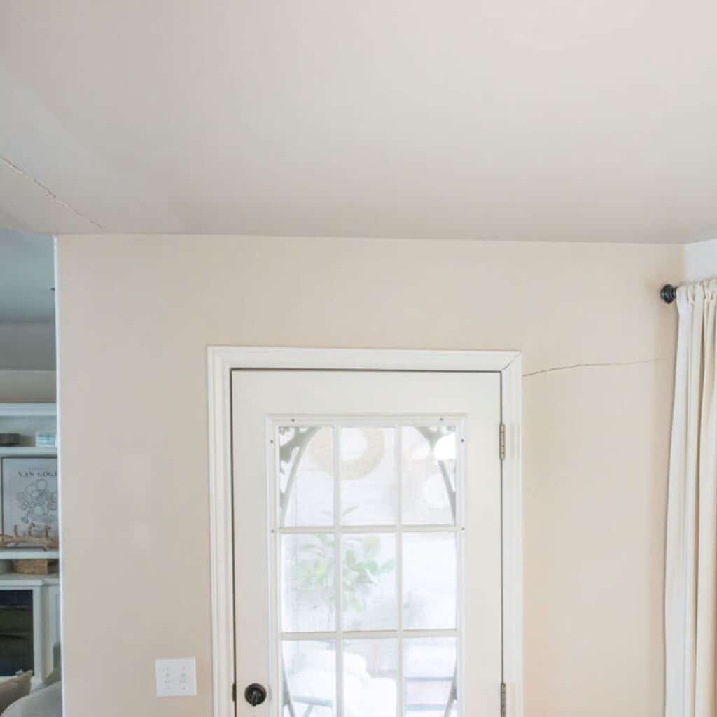 A visible crack runs along the interior wall near a doorframe, indicating potential foundation issues
