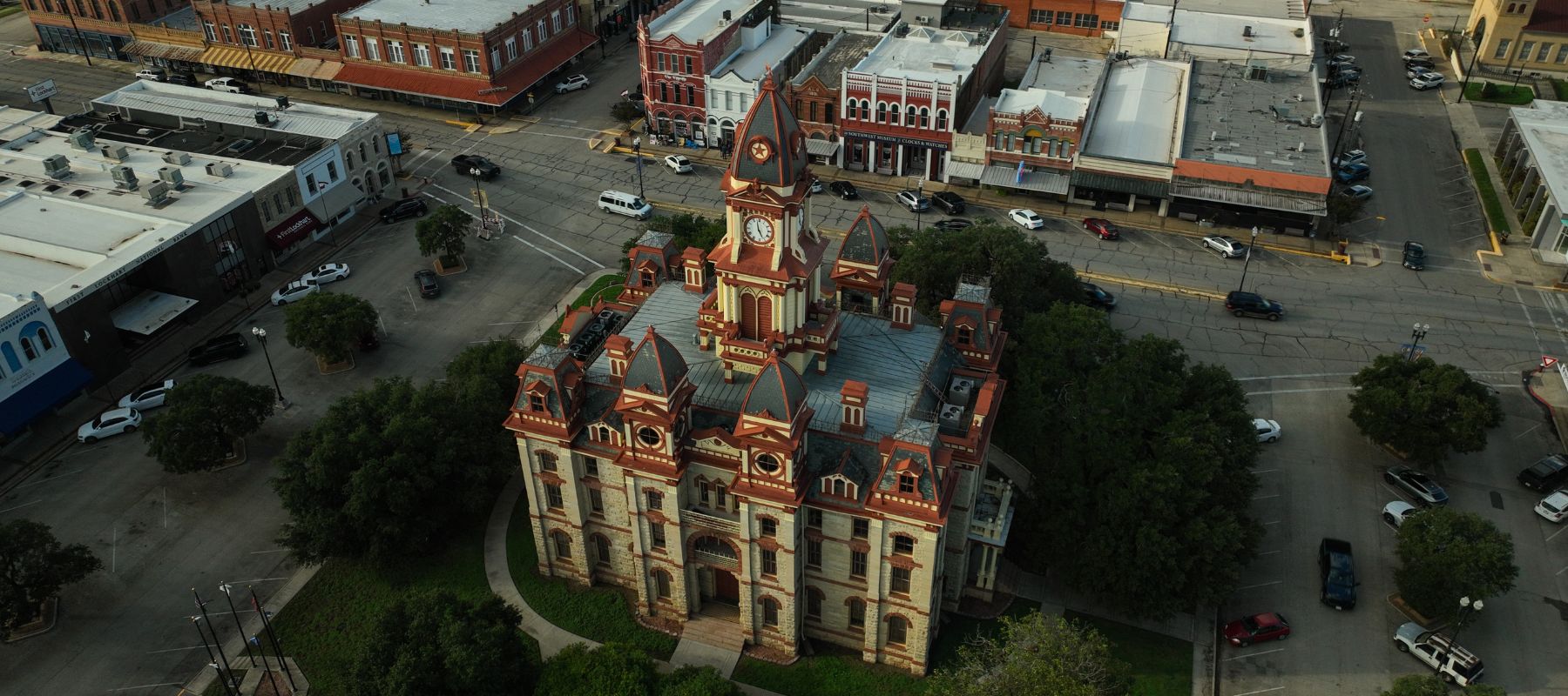 Aerial view of the ornate red-and-white Caldwell County Courthouse in Lockhart, Texas